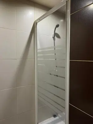 a shower with a shower head in a bathroom at Appartement sous les toits in Piana