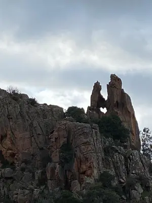 a large rocky mountain with trees on top of it at Appartement sous les toits in Piana
