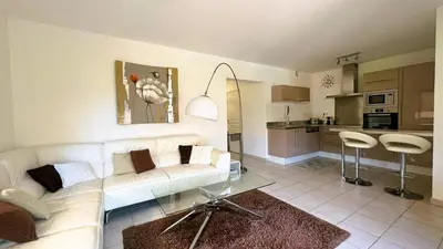 a living room with a white couch and a kitchen at Appartement Laurel, 4 personnes, piscine, plage à 2 min en voiture in Lecci