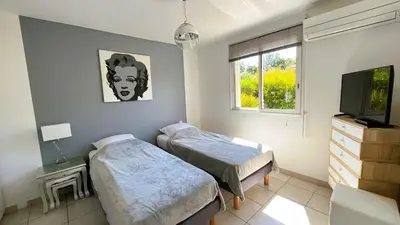 a bedroom with two beds and a tv and a window at Appartement Laurel, 4 personnes, piscine, plage à 2 min en voiture in Lecci