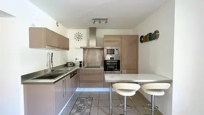 a kitchen with a counter and two bar stools at Appartement Laurel, 4 personnes, piscine, plage à 2 min en voiture in Lecci