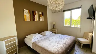 a bedroom with a bed and a chair and a window at Appartement Laurel, 4 personnes, piscine, plage à 2 min en voiture in Lecci