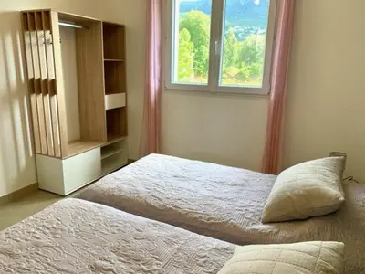 a bedroom with two beds and a window at VILLA PETRETO in Petreto-Bicchisano