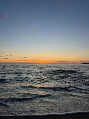 a view of the ocean with the sun setting at VILLA PETRETO in Petreto-Bicchisano