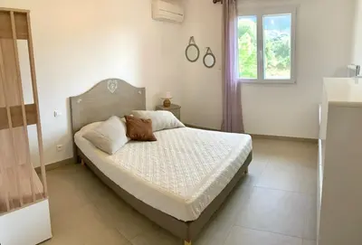 a bedroom with a bed in a room with a window at VILLA PETRETO in Petreto-Bicchisano