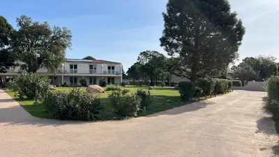 a driveway leading to a house with trees and bushes at Résidence Fiori di Cala Rossa in Lecci