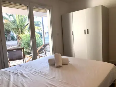 a bedroom with a white bed and a large window at Résidence Fiori di Cala Rossa in Lecci