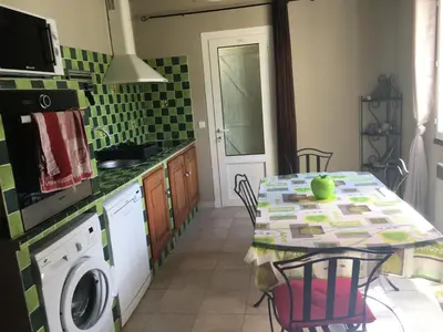 a kitchen with a table and a washing machine at Casa maria in Porto-Vecchio
