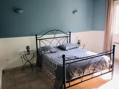a bedroom with a bed and two side tables at Casa maria in Porto-Vecchio