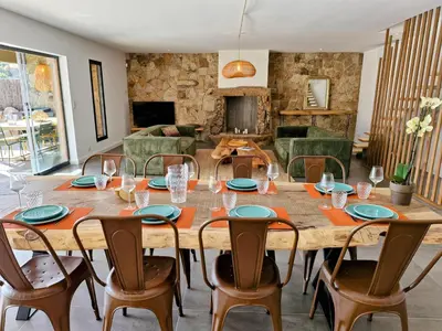 a large wooden table with chairs and a living room at NOUVEAUTE! Magnifique villa à 2 minutes des plus belles plages de la rive sud in Porticcio