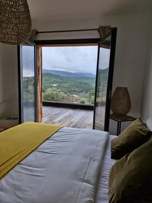 a bedroom with a bed and a large glass window at NOUVEAUTE! Magnifique villa à 2 minutes des plus belles plages de la rive sud in Porticcio
