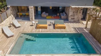 an overhead view of a swimming pool with chairs and a table at NOUVEAUTE! Magnifique villa à 2 minutes des plus belles plages de la rive sud in Porticcio