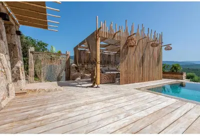a wooden deck next to a swimming pool with a fence at NOUVEAUTE! Magnifique villa à 2 minutes des plus belles plages de la rive sud in Porticcio