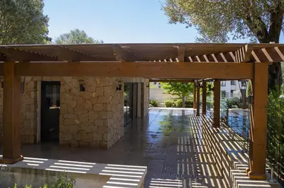 a wooden pergola in front of a building at Domaine d'Arca - Eluard 04 - 6 pers in Porto-Vecchio