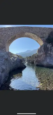 a stone bridge over a body of water at Maison de village in Manso