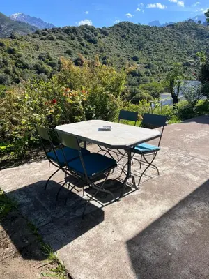 a table and chairs with a view of a mountain at Maison de village in Manso