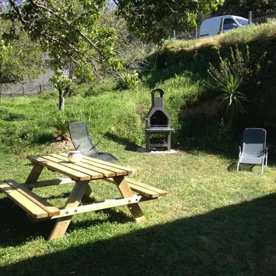 a picnic table and a grill in a yard at Maison de village in Manso
