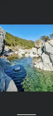 a picture of a river with rocks and water at Maison de village in Manso