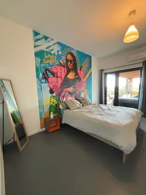 a bedroom with a bed with a painting on the wall at Villa Lavu Santu piscine privée vue mer/montagnes in Zonza