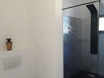 a bathroom with a shower with a glass door at Villa Lavu Santu piscine privée vue mer/montagnes in Zonza