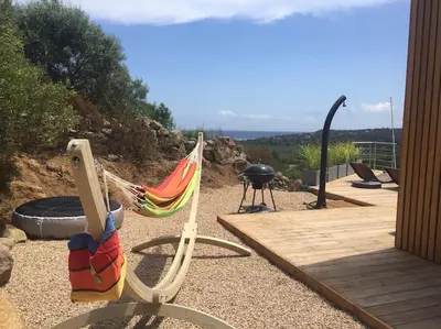 a hammock sitting next to a grill on a patio at Villa Lavu Santu piscine privée vue mer/montagnes in Zonza