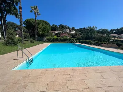 a blue swimming pool with a chair in a yard at Maison charmante à San-Nicolao 55 m² avec piscine partagée in San-Nicolao