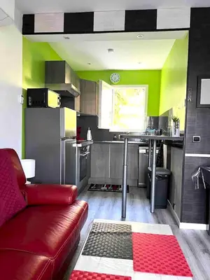 a kitchen with a red couch in a room at Maison charmante à San-Nicolao 55 m² avec piscine partagée in San-Nicolao