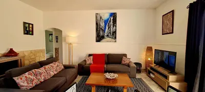 a living room with a couch and a tv at Villa Bella Vista, 4ch, piscine in Figari