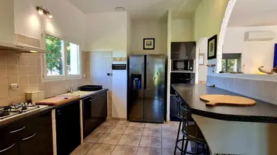 a kitchen with a stainless steel refrigerator in it at Villa Bella Vista, 4ch, piscine in Figari