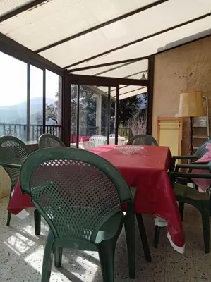 a table with a red table cloth on a patio at Maison individuelle au calme in Valle-di-Mezzana