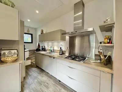 a kitchen with white cabinets and a stove top oven at Maison entre les montagnes à Levie in Levie