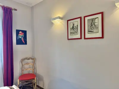 a room with three pictures on the wall and a chair at Maison entre les montagnes à Levie in Levie