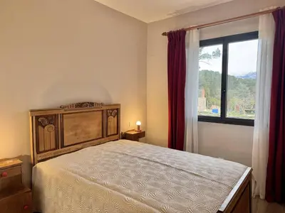 a bedroom with a large bed and a window at Maison entre les montagnes à Levie in Levie