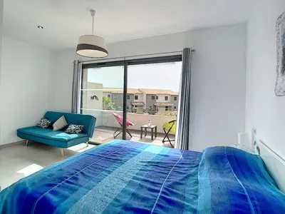 a bedroom with a blue bed and a large window at Porto vecchio - St.cyprien - Corse du sud -plages in Lecci