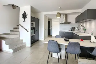 a kitchen with a table and chairs and a staircase at Porto vecchio - St.cyprien - Corse du sud -plages in Lecci