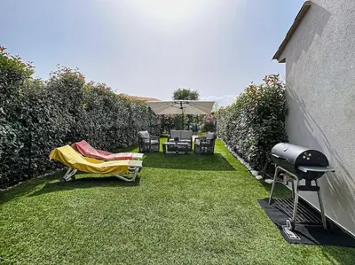 a backyard with a grill and chairs and a blanket at Porto vecchio - St.cyprien - Corse du sud -plages in Lecci