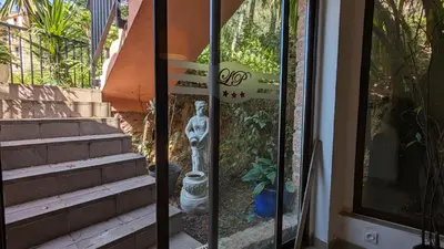 a glass door with a statue next to some stairs at Le Porto T3 55m2 vue mer immeuble traditionnel en pierre de taille avec prestations exceptionnelles barbecue ordinateur vidéosurveillance terrasse panoramique in Porto Ota