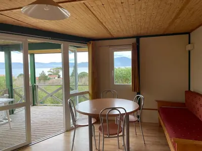 a dining room with a table and chairs and a balcony at La vallee 3 in Belvédère