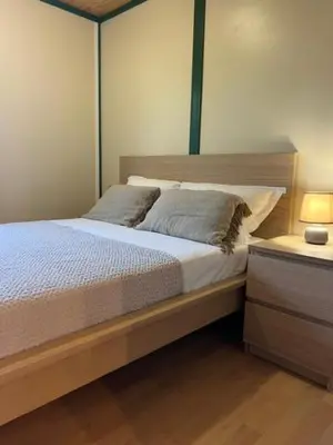 a bedroom with a large bed with a wooden headboard at La vallee 3 in Belvédère