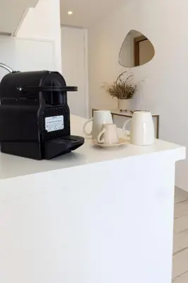 a black toaster sitting on a kitchen counter with mugs at La Manufacture D'oriano LES NUITS AU VILLAGE in Montegrosso
