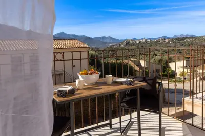 a table with a bowl of fruit on a balcony at La Manufacture D'oriano LES NUITS AU VILLAGE in Montegrosso