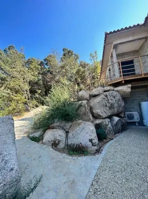 a house with a bunch of rocks and a building at Villa Trinita Paradis privé piscine et loisirs in Porto-Vecchio