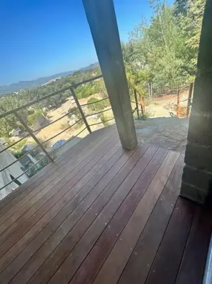 a balcony with a wooden deck with a railing at Villa Trinita Paradis privé piscine et loisirs in Porto-Vecchio