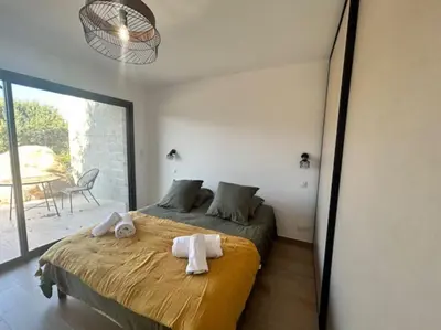a bedroom with a bed with towels on it at Villa Trinita Paradis privé piscine et loisirs in Porto-Vecchio