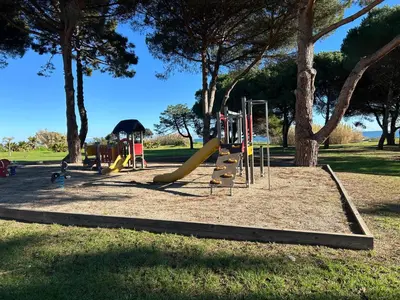 a playground in a park with a slide at Rez de Jardin Piscine et Plage in Poggio-Mezzana