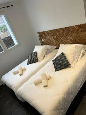 two beds in a room with white sheets and pillows at A nepita di porto vecchio*** in Porto-Vecchio