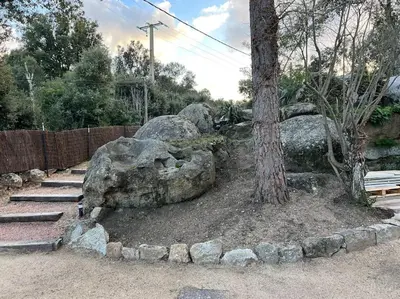 a rock garden with a tree and a bench at A nepita di porto vecchio*** in Porto-Vecchio