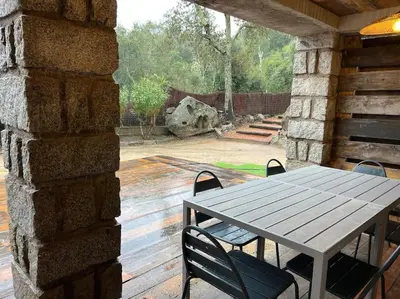 a wooden table and chairs on a patio at A nepita di porto vecchio*** in Porto-Vecchio