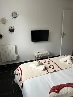a bedroom with a bed with a tv on the wall at A nepita di porto vecchio*** in Porto-Vecchio