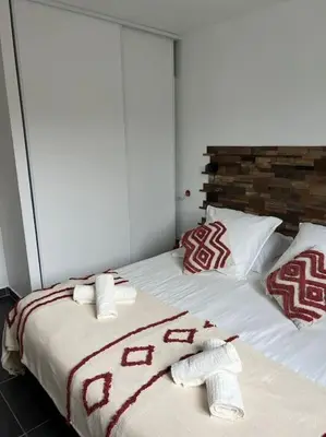 a bed with red and white blankets and pillows at A nepita di porto vecchio*** in Porto-Vecchio